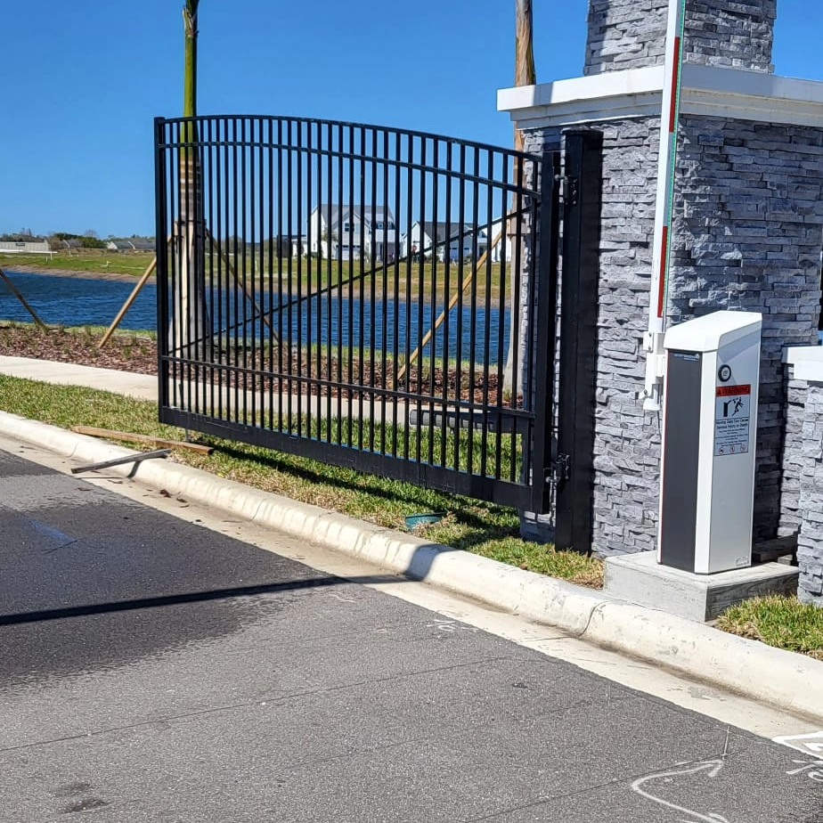Black aluminum fence and entry gate with stone pillar — fence installation
